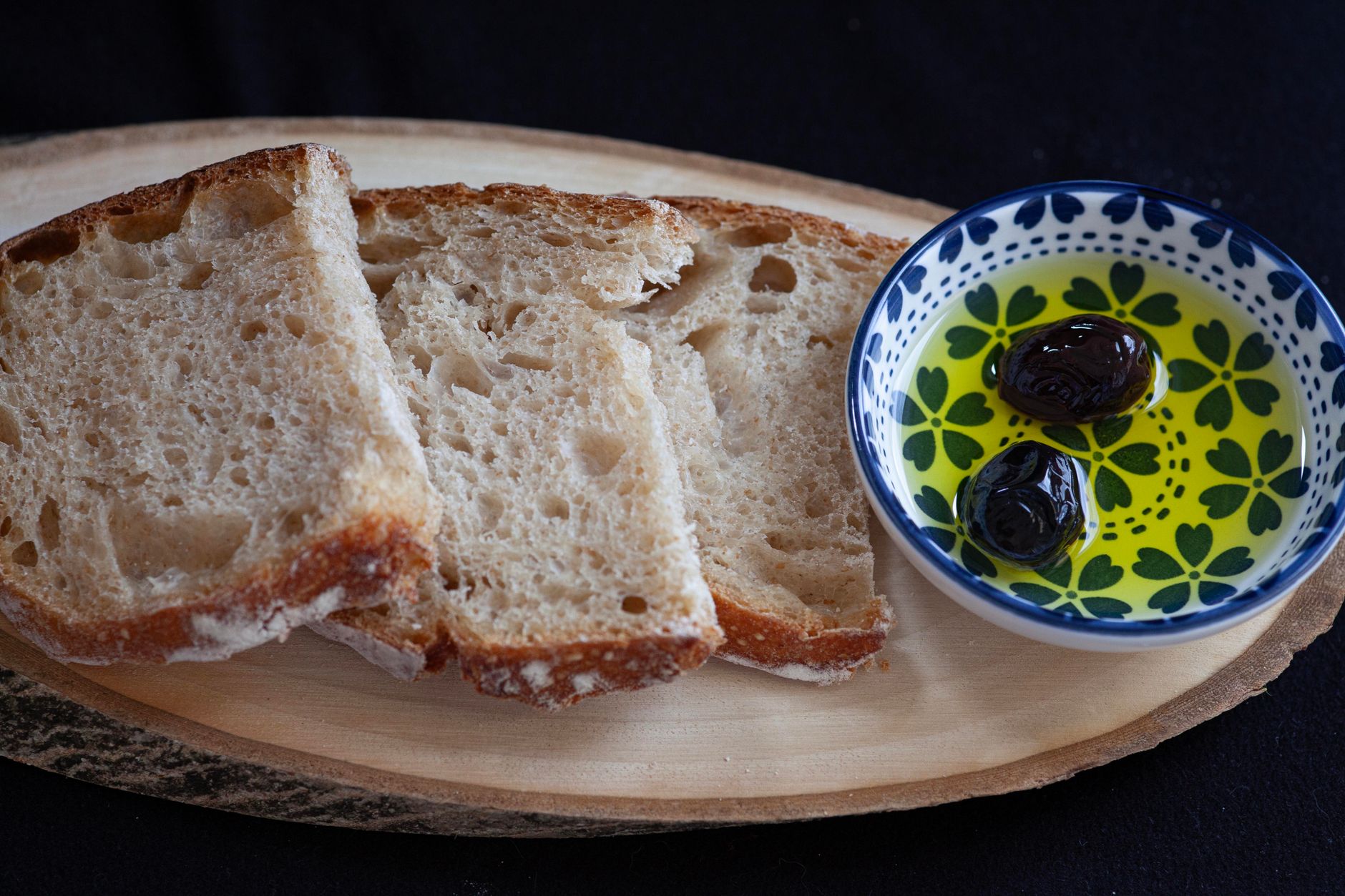 Rustic wooden table with fresh crusty bread, rosemary, and olive oil